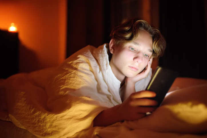 boy on his phone in bedroom