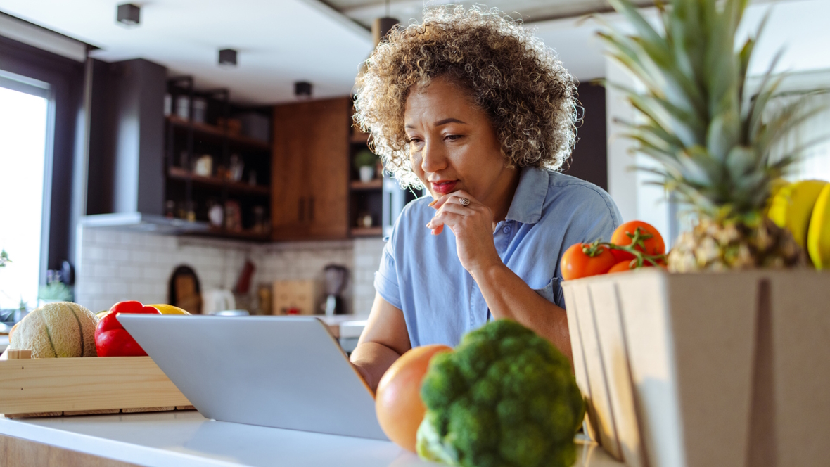 Woman sitting in front of a laptop ordering groceries online