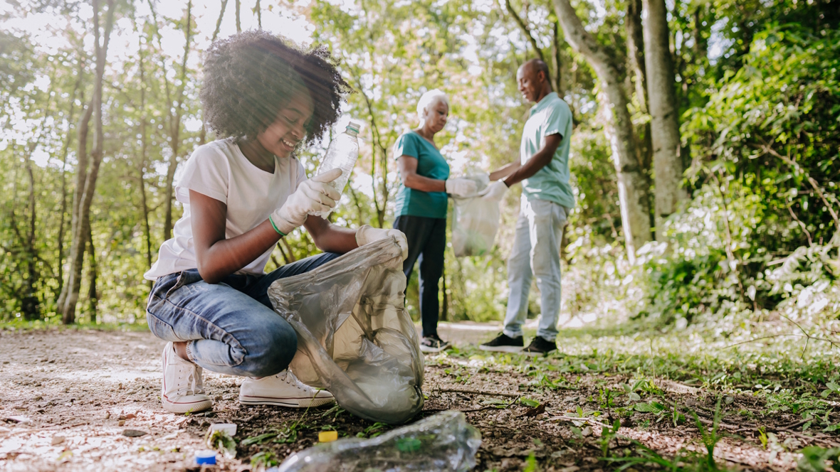 Families demonstrating environmental sustainability by picking up trash at a park