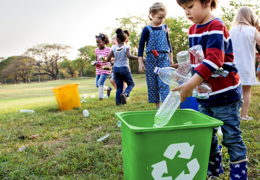 Kids putting plastic in recycle bins
