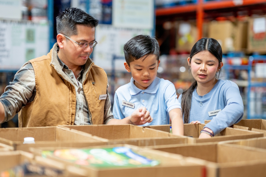 Kids volunteering at a food bank with their dad