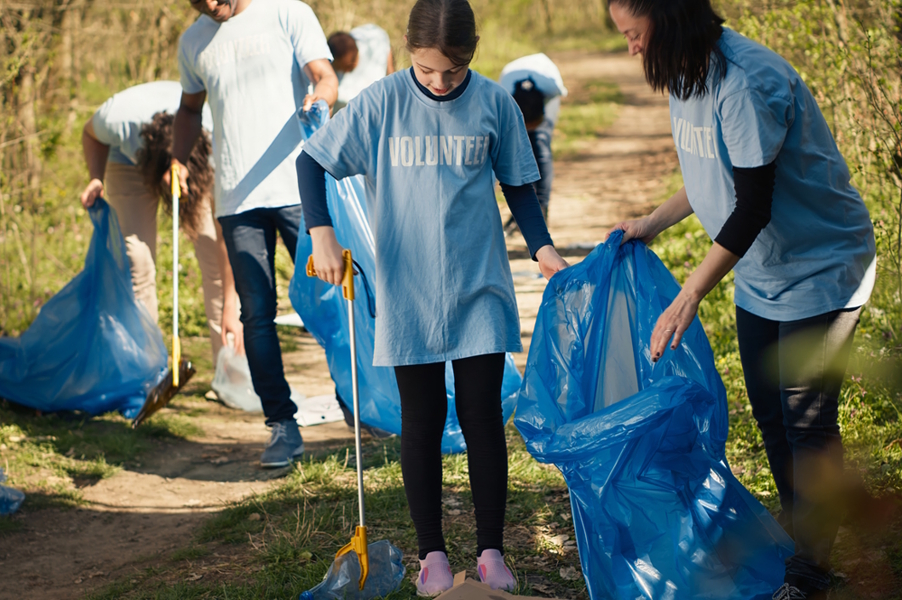 Young girl participating in a trash clean up as a volunteer
