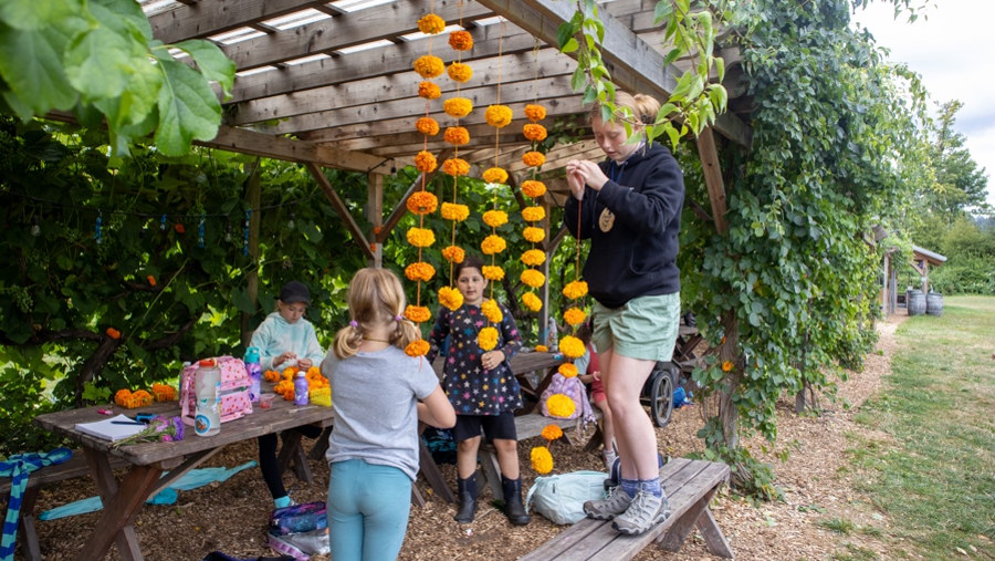 Campers making a flower chain at Oxbow kid-centered summer camp