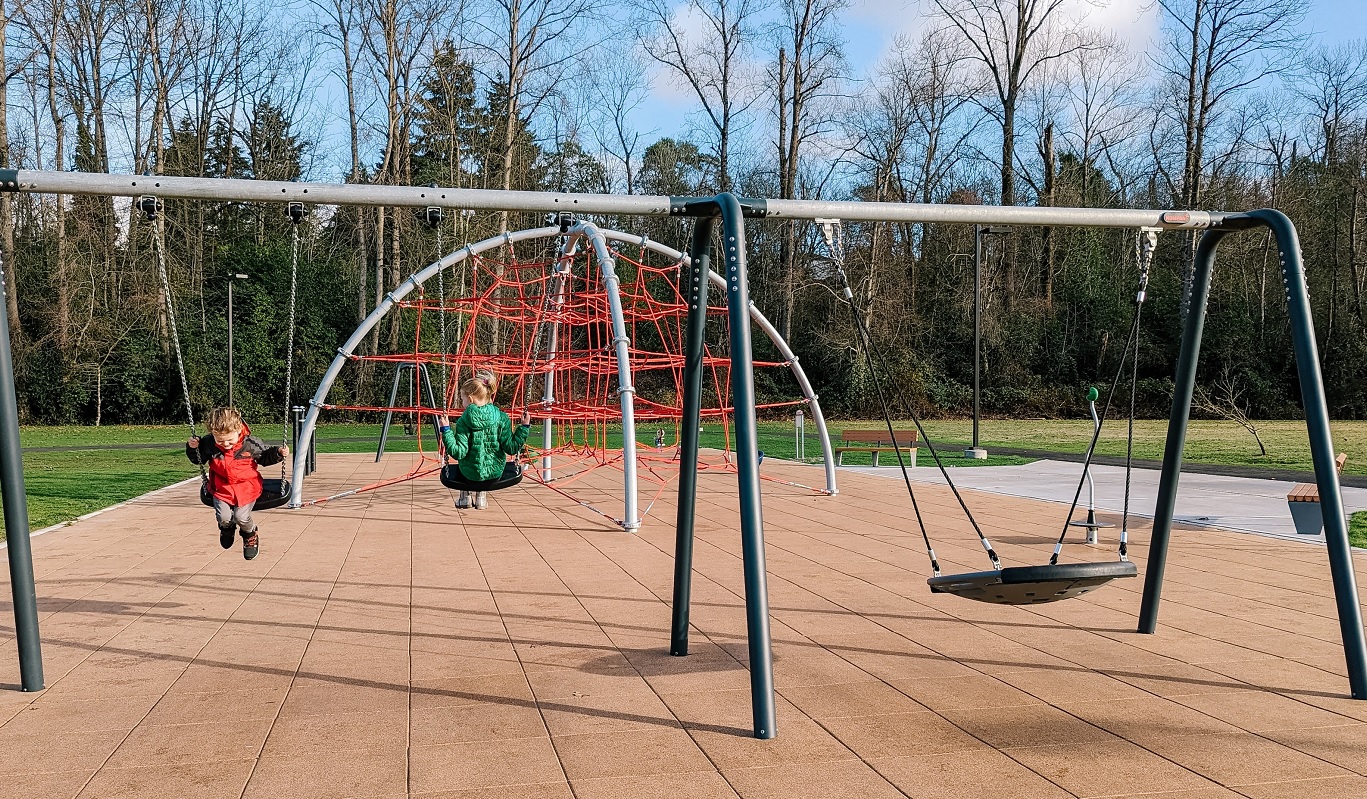 Kids swing happily on the new swing set installed at Skyway Park's new playground Seattle fun parks for kids