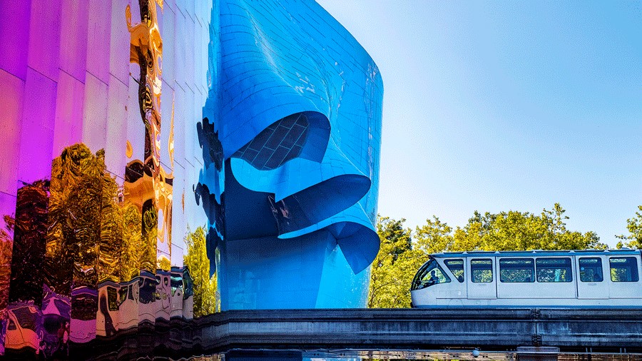 The Seattle Center Monorail outside MoPOP on a sunny day