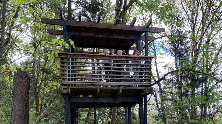 Three kids look out from the tree house tower at Mercer Slough Environmental Education Center near Seattle