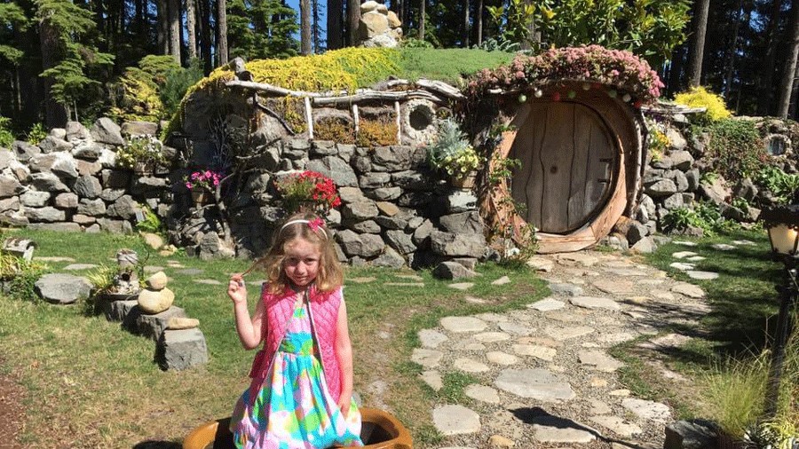 Young girl stands in front of a hobbit house at The Brothers Greenhouses in Port Orchard