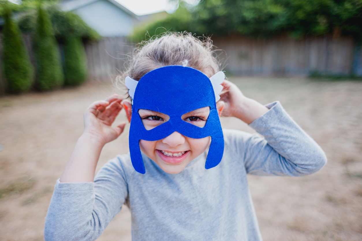 a child wears a superhero felt mask from a DIY birthday goody bag