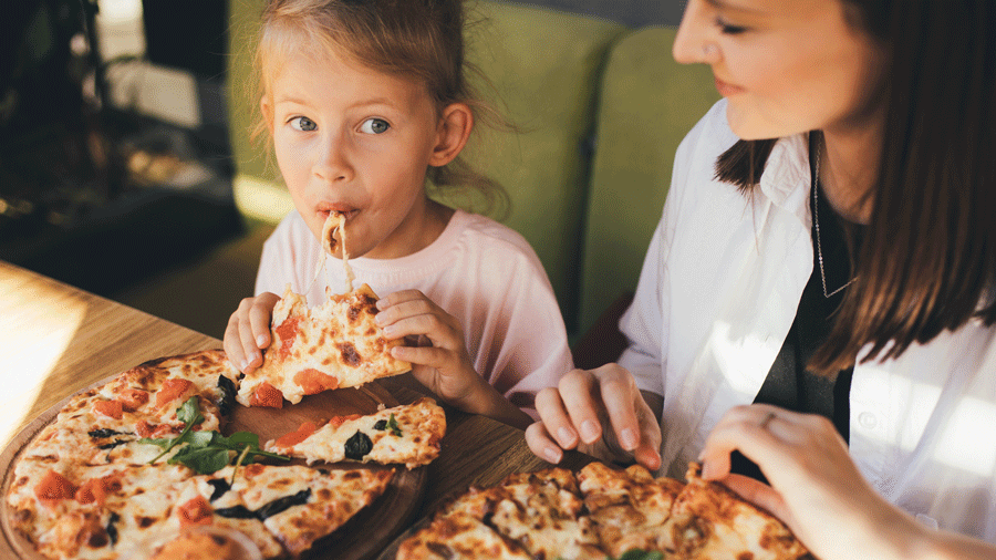 mom and daughter enjoying pizza in Seattle