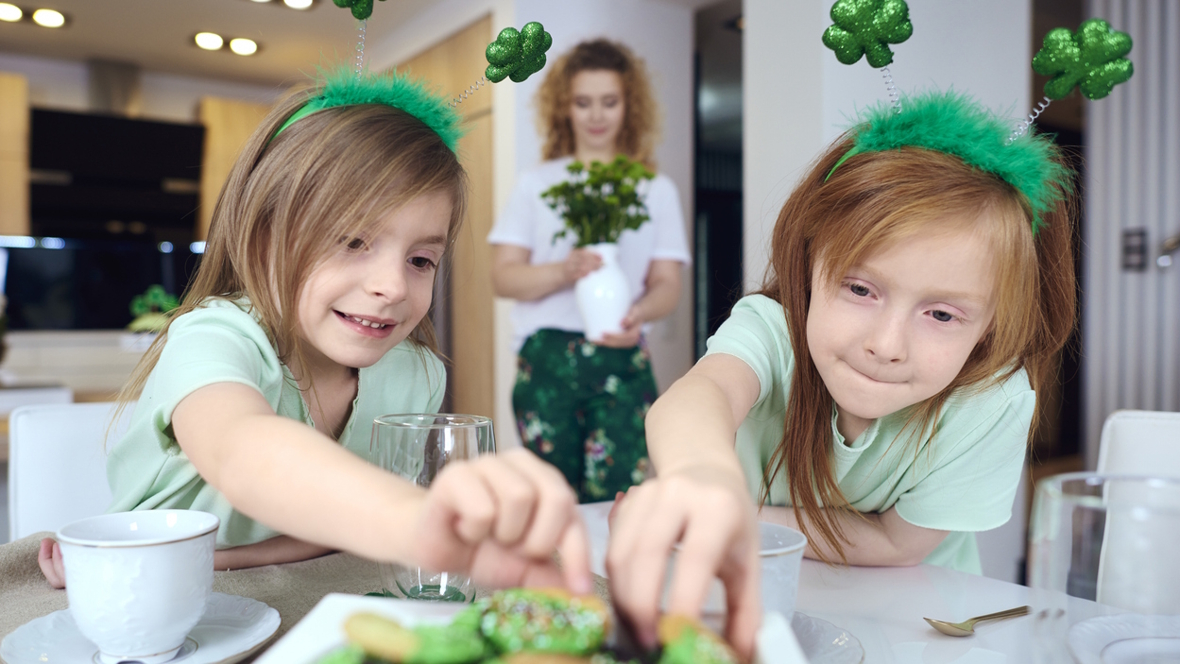 two girls reaching for a St. Patrick's Day treat
