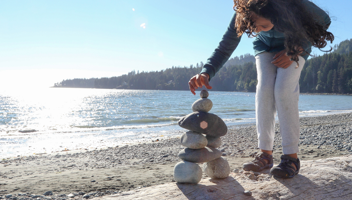 girl-building-rock-cairn-beach-nature-treasure-hunt-what-to-find-at-the-park-around-the-block