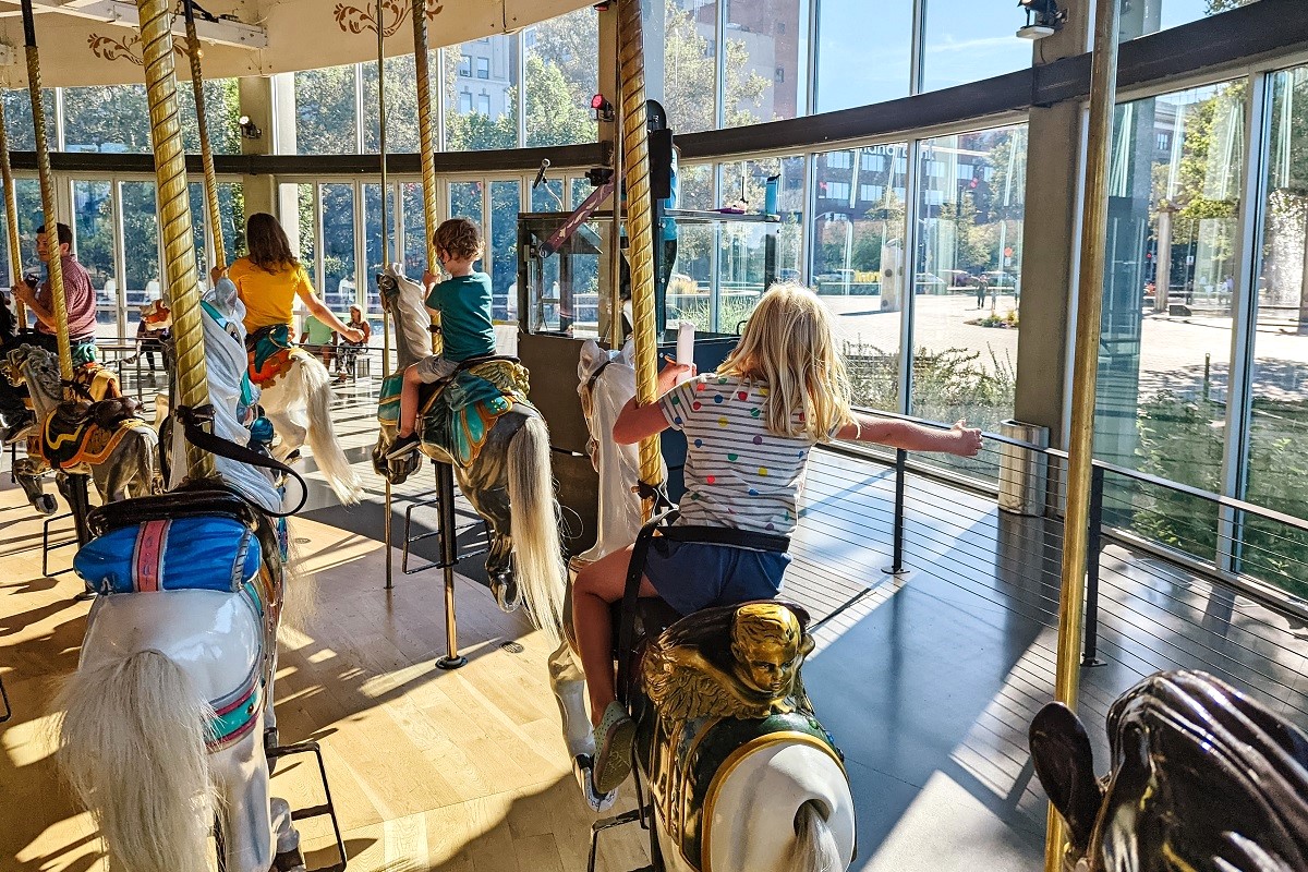 A child rides on a carousel horse on the Looff Carrousel in Spokane’s Riverfront Park, among kid-friendly fun to find on a family getaway to Spokane