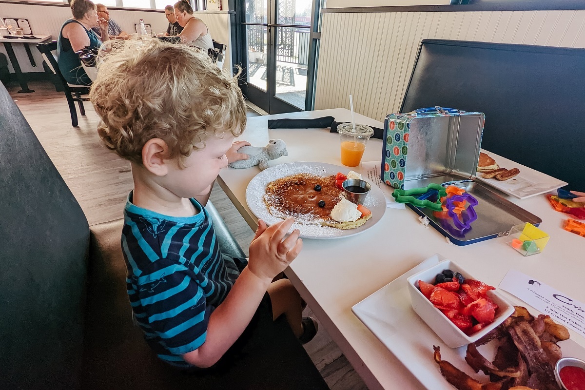 A young diner delights at the sight of his teddy bear hotcake from Crimson Hearth family-friendly dining Spokane