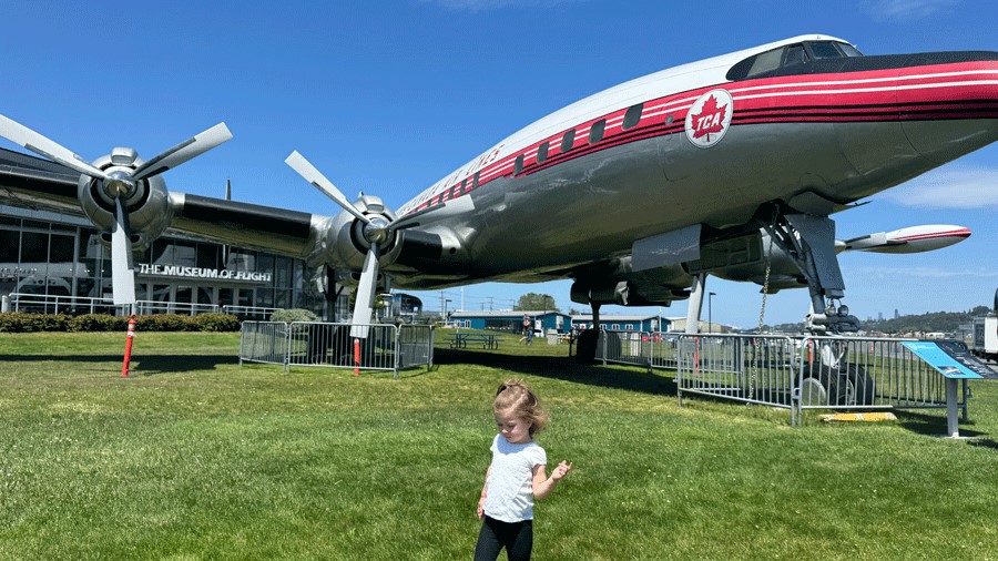 Toddler at the Museum of Flight in front of an airplane, one of the best things to do in Seattle with toddlers where their ticket is free