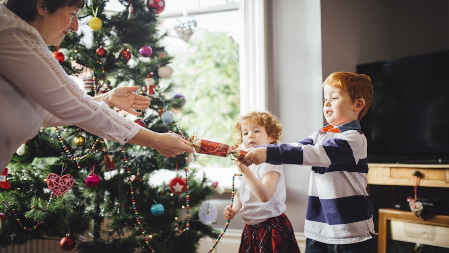 Kid and grandma pulling apart a Christmas cracker