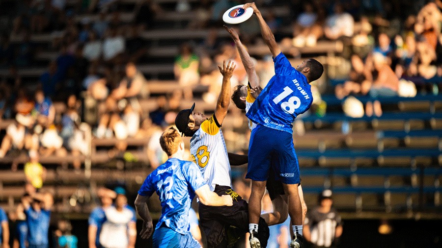 ultimate players jumping toward a disc during a Seattle Cascades ultimate game, a family-friendly and affordable sports outing