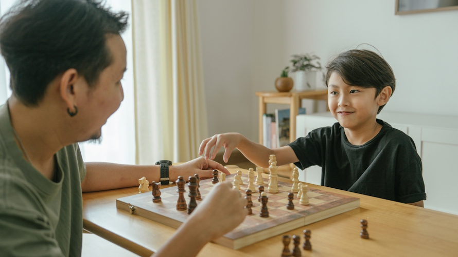 Dad and son playing chess one on one time