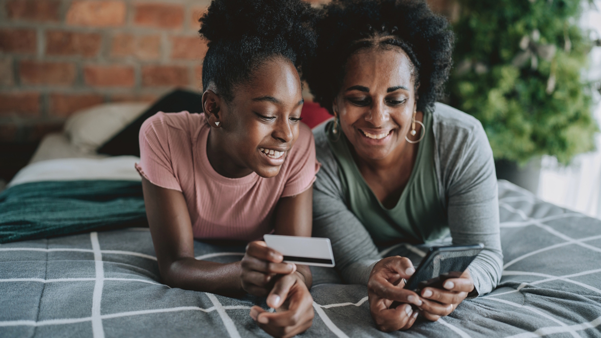 mom showing teen girl how to use new debit card