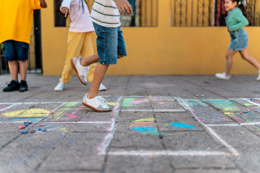 children playing outside with sidewalk chalk