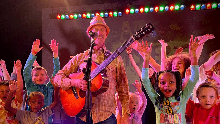 MISTER G live performance with kids smiling on stage