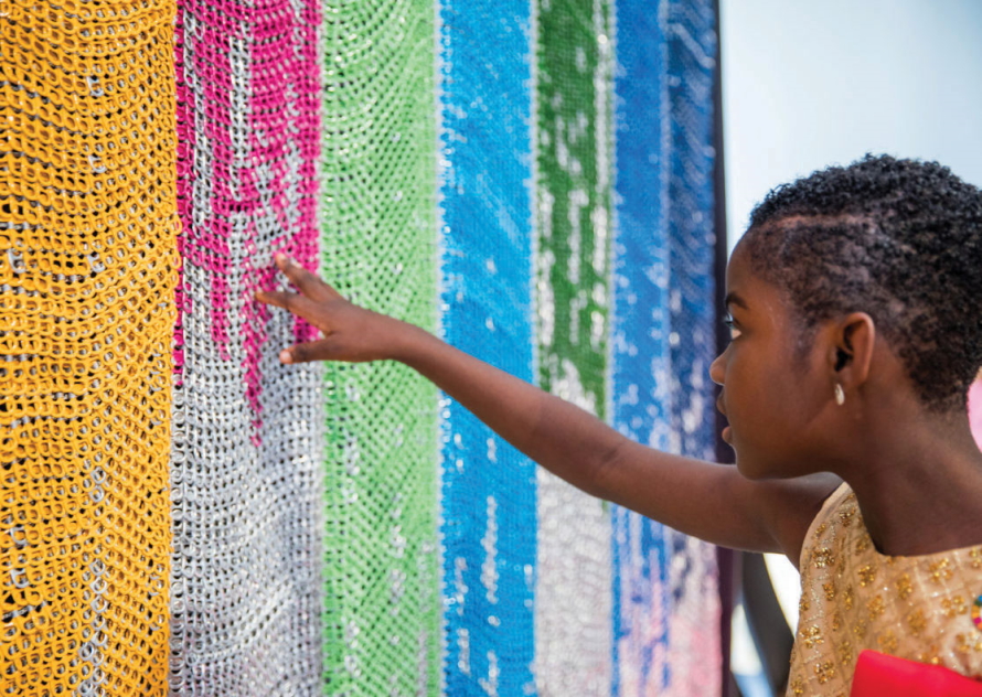 Young girl standing in front of a colorful wall