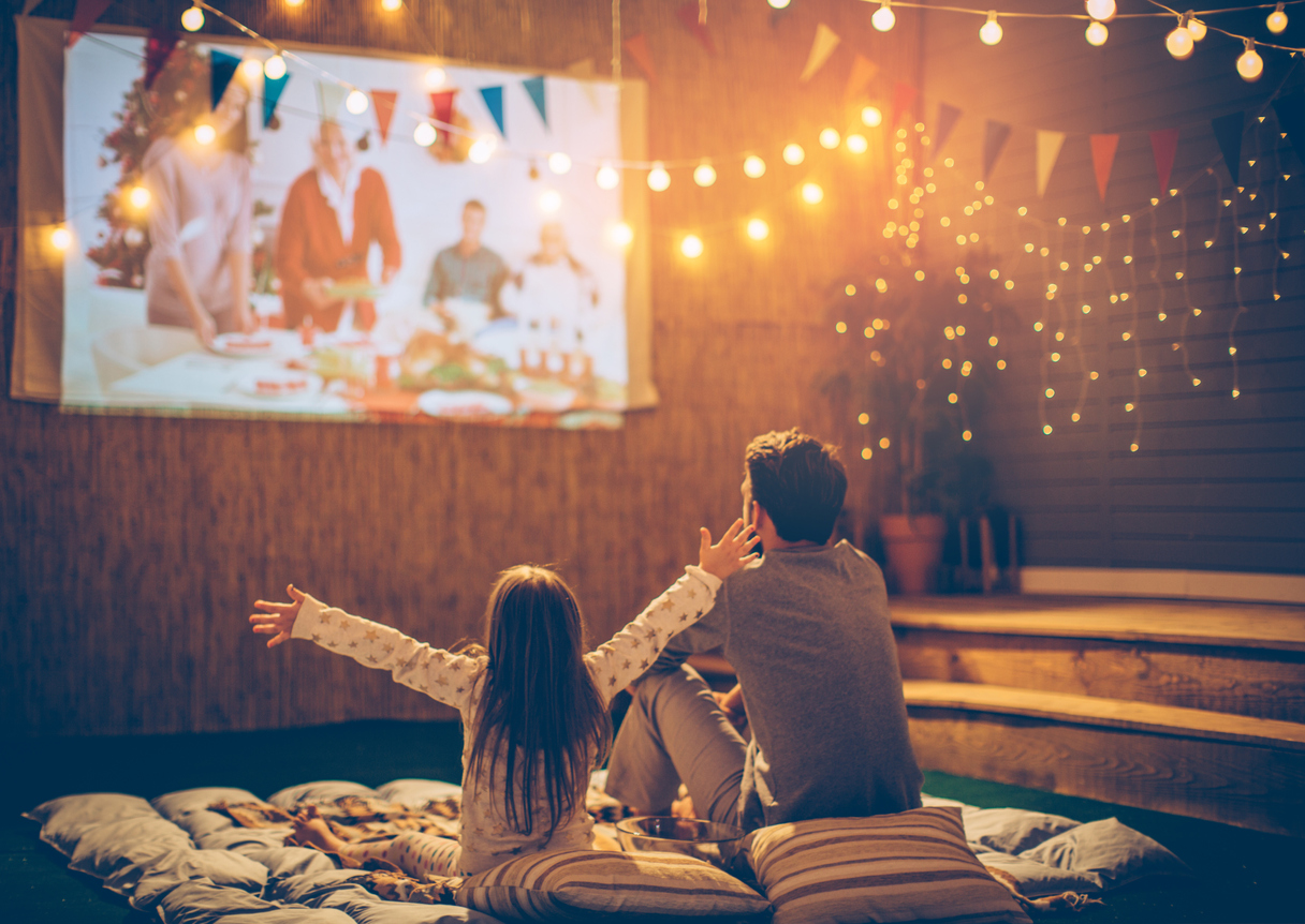 Little girl and dad watching a movie outside