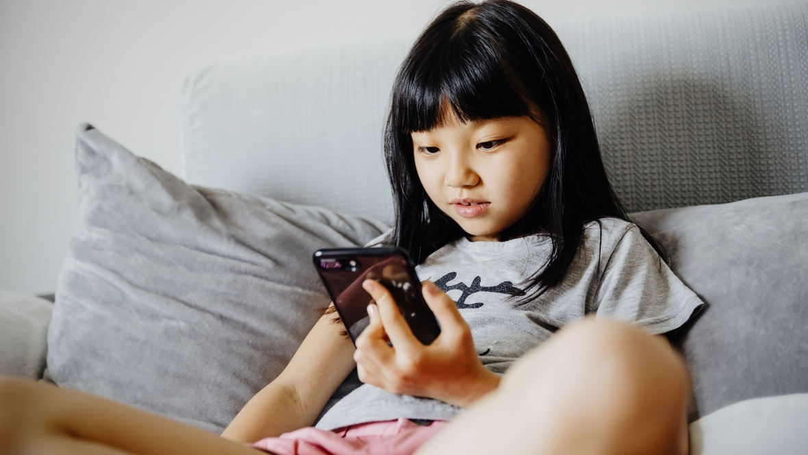 young girl looking at social media on her phone might be part of The Anxious Generation