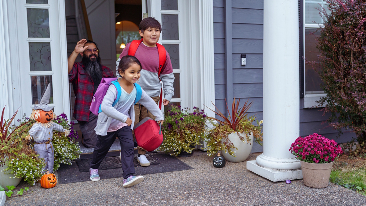 brother and sister heading out the door to school