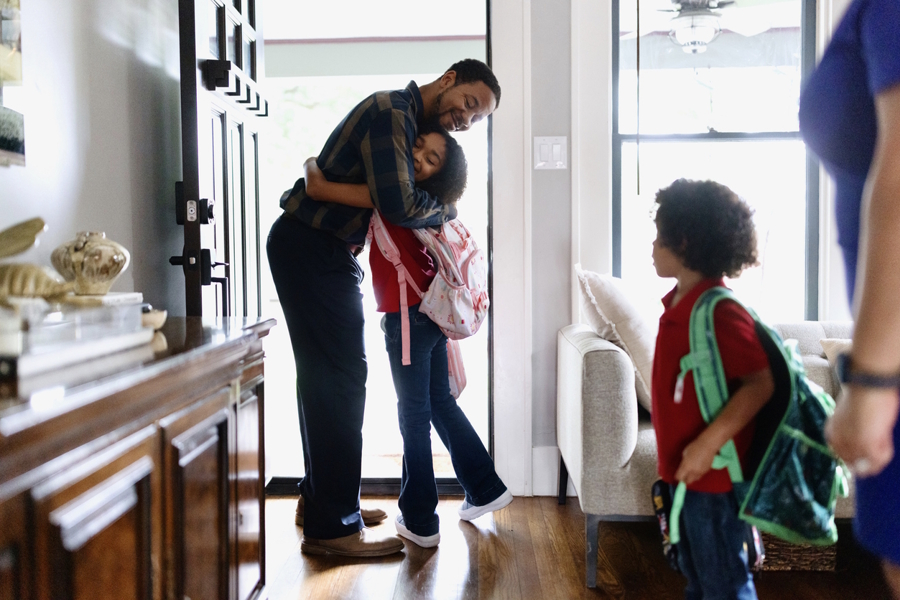 dad giving daughter a hug after school