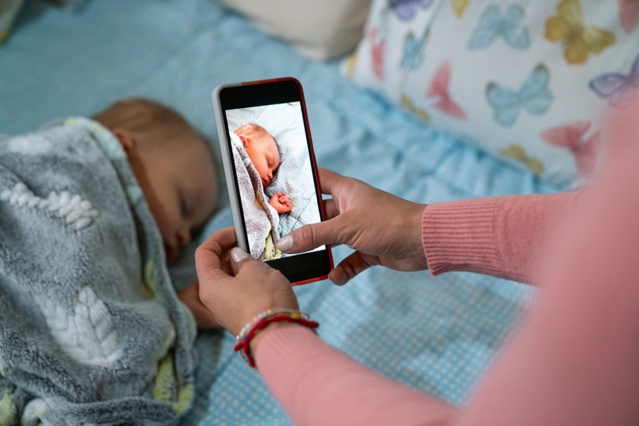 Nanny taking a picture of a sleeping baby