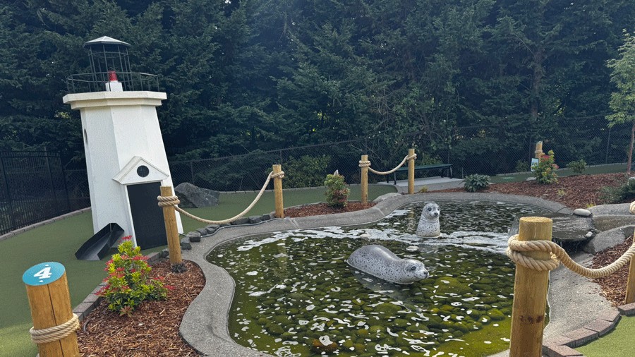 mini lighthouse and seals in a water feature on the mini golf course at penmet