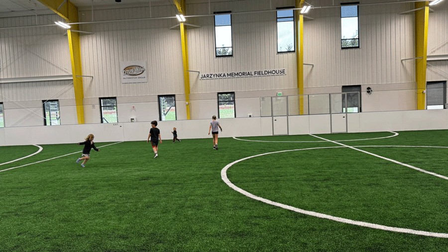 kids playing on the turf in the fieldhouse at the new PenMet rec center