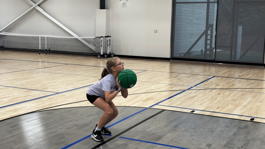 Kid playing basketball on the court at the new PenMet rec center in Gig Harbor