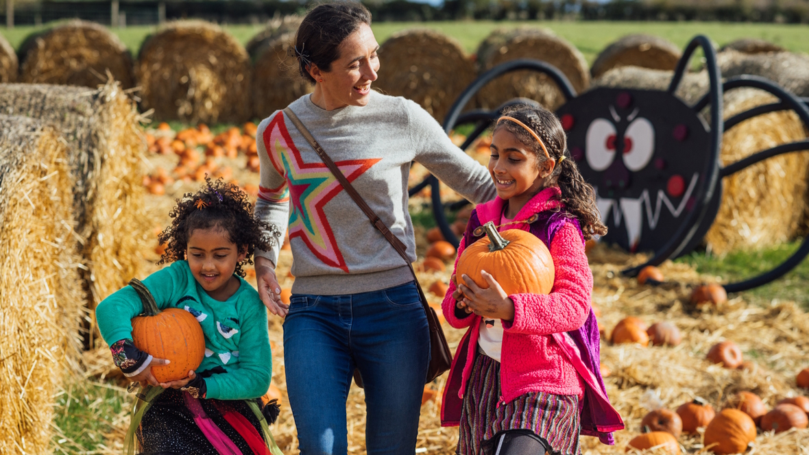 Mom and two daughters picking pumpkins at a pumpkin patch near Seattle