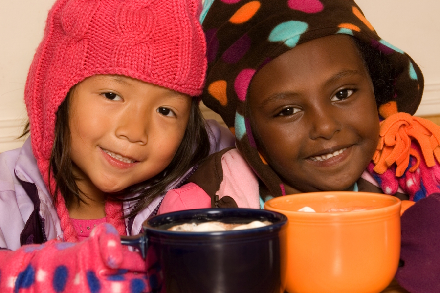 Two girls drinking hot chocolate at a season outdoor ice-skating rink near Seattle