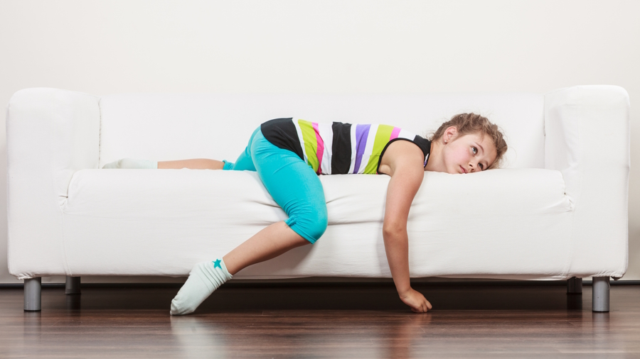 a child on a couch looking bored at home