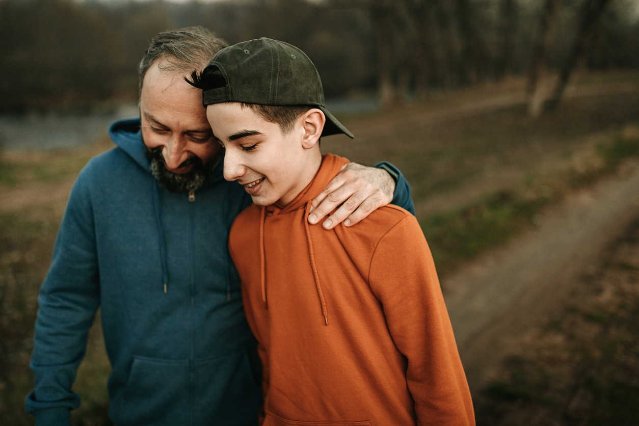 dad and teen son take a walk outside