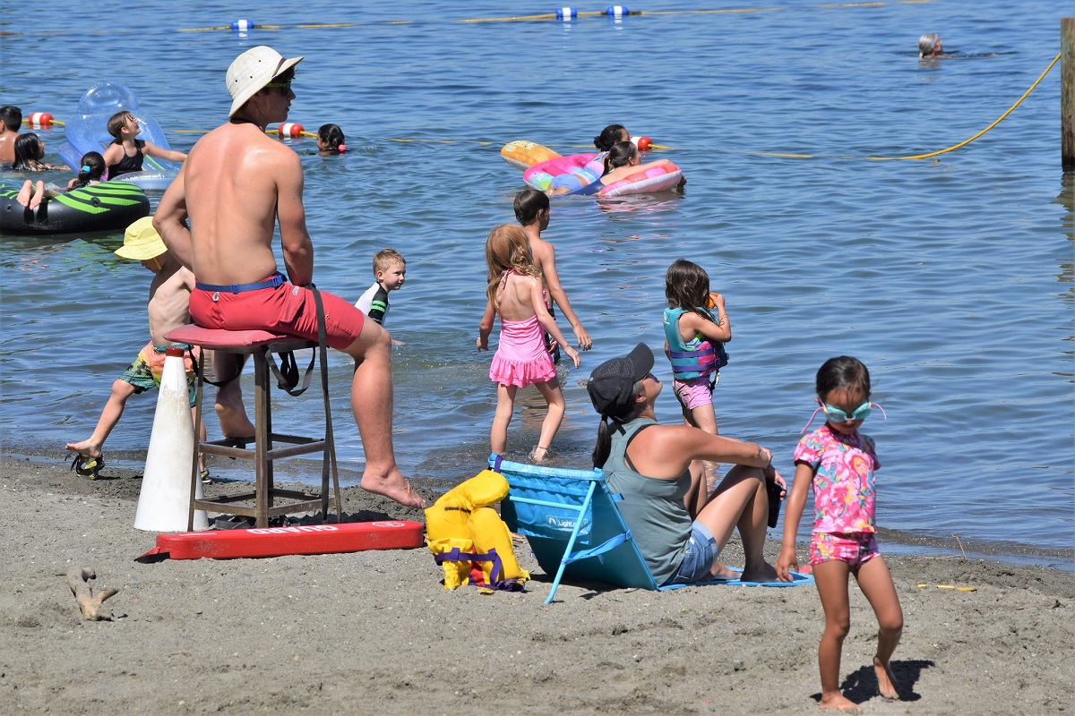 A lifeguard watches children swim at Seattle swimming beach where to swim in Seattle Mount Baker Beach on Lake Washington