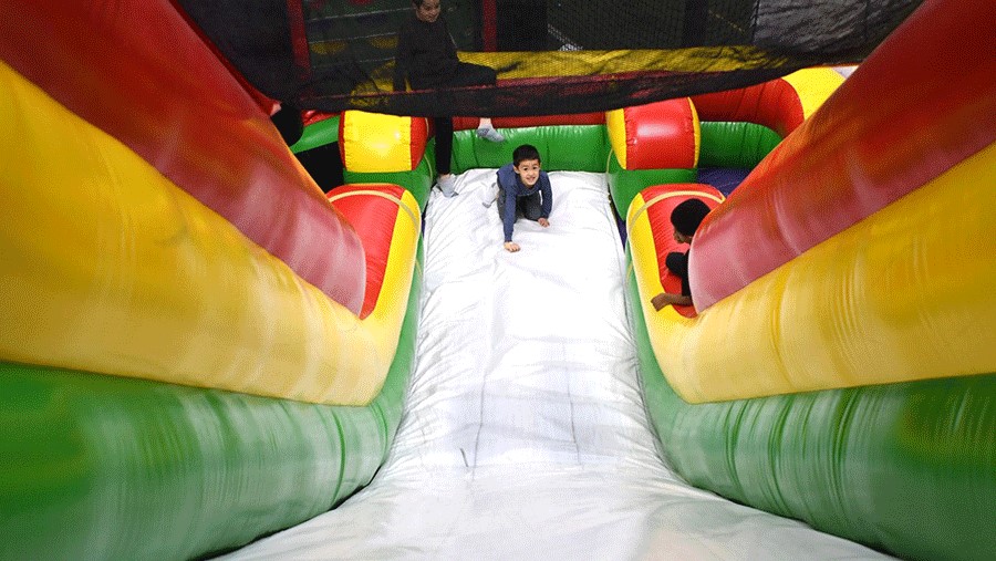 Young boy on an inflatable slide at Arena Sports, a Seattle indoor playground