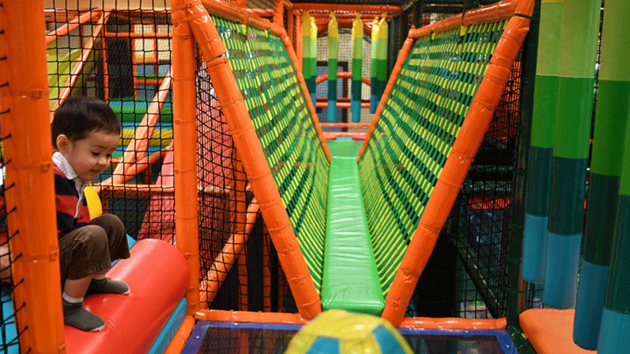 Young boy at a Seattle indoor playground, playing on the Safari obstacle course