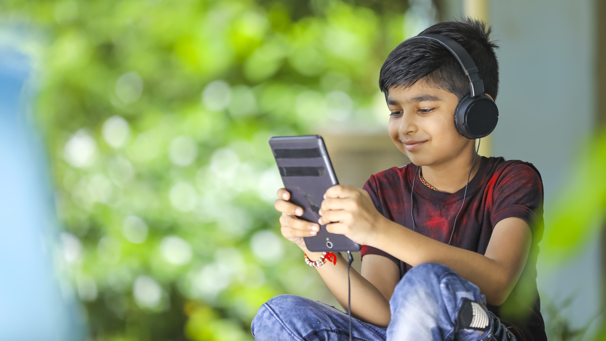 Young boy wearing headphones using an education app