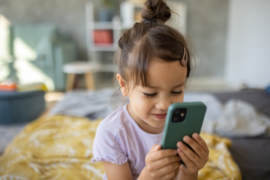 Young girl using a smart phone and looking at an education app