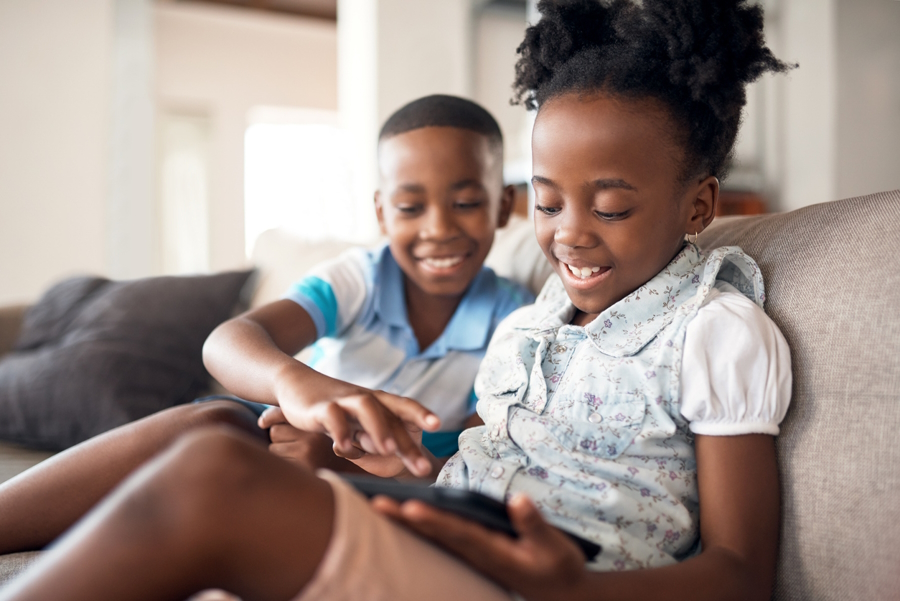 A brother and sister having fun using an education app on a smartphone