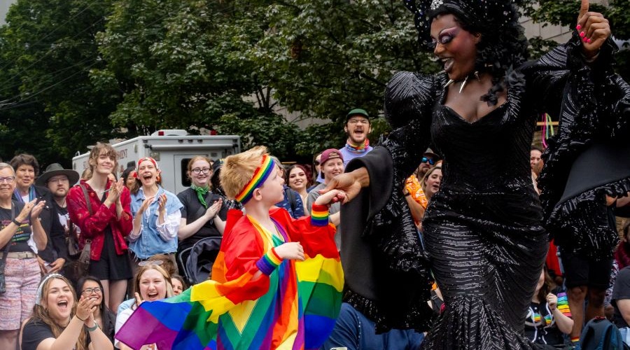 A young boy hand in hand with a drag queen at the Seattle Pride Parade