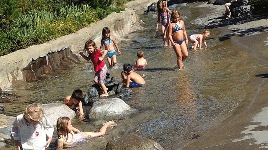 East Bay Public Plaza reclaimed stream with kids playing during the summer in Olympia
