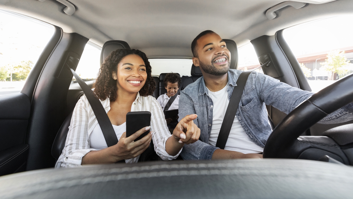 family driving in a car on vacation using an app to help save money
