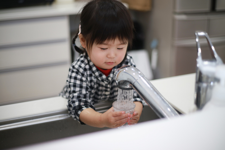 a child fills up her own glass of water and learns that she’s capable