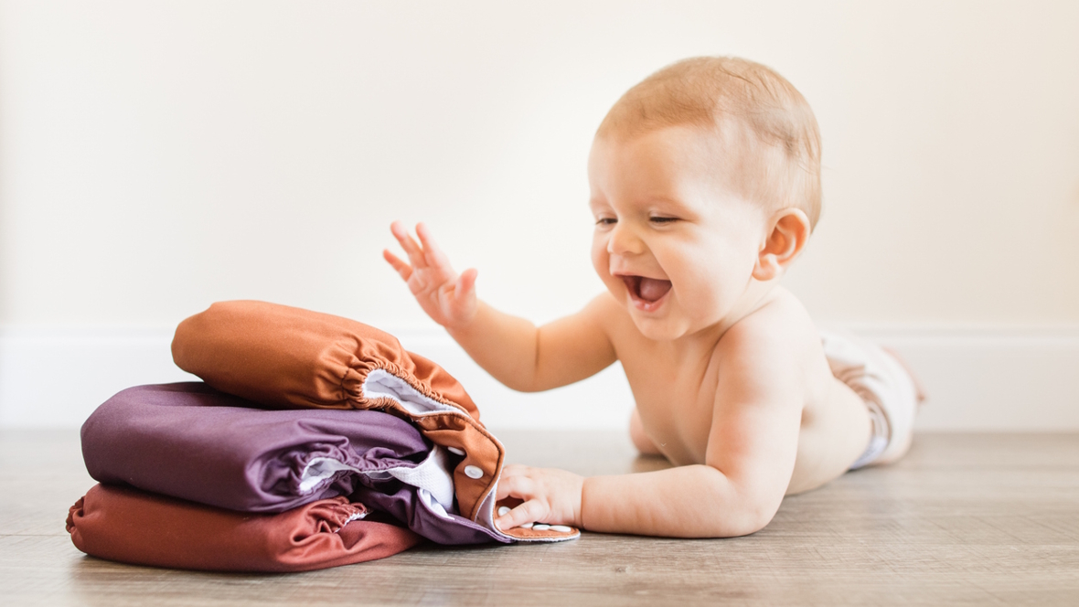 Baby with a stack of cloth diapers