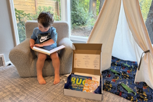 boy sitting in a chair reading a book