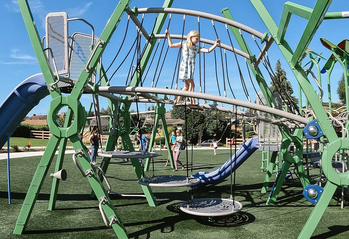 A girl climbs on the big kid climber structure at the new playground at Emma Yule Park in Everett